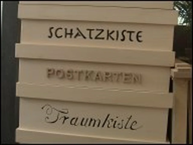 Gestapelte Kunstkisten mit den Worten Schatzkiste, Postkarten und Traumkiste